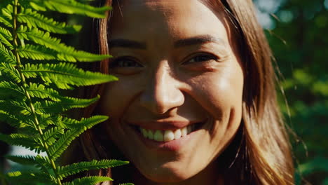 smiling woman with fern in nature