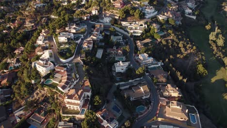 aerial birds eye flight showing luxury villa with swimming pool in hilltop of malaga city at sunset