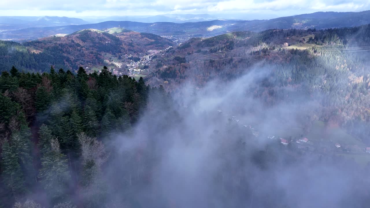 descenso lento aéreo sobre un bosque oscuro y frío súper malhumorado en plainfaing vosges con nubes de rápido movimiento en 4k
