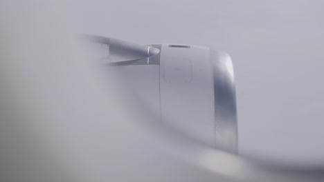 airplane engine view through window with soft clouds and overcast sky