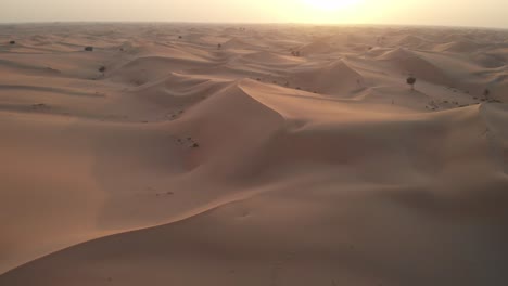 Drone-Volando-Hacia-La-Puesta-De-Sol-En-El-Desierto-De-Abu-Dhabi,-Emiratos-árabes-Unidos