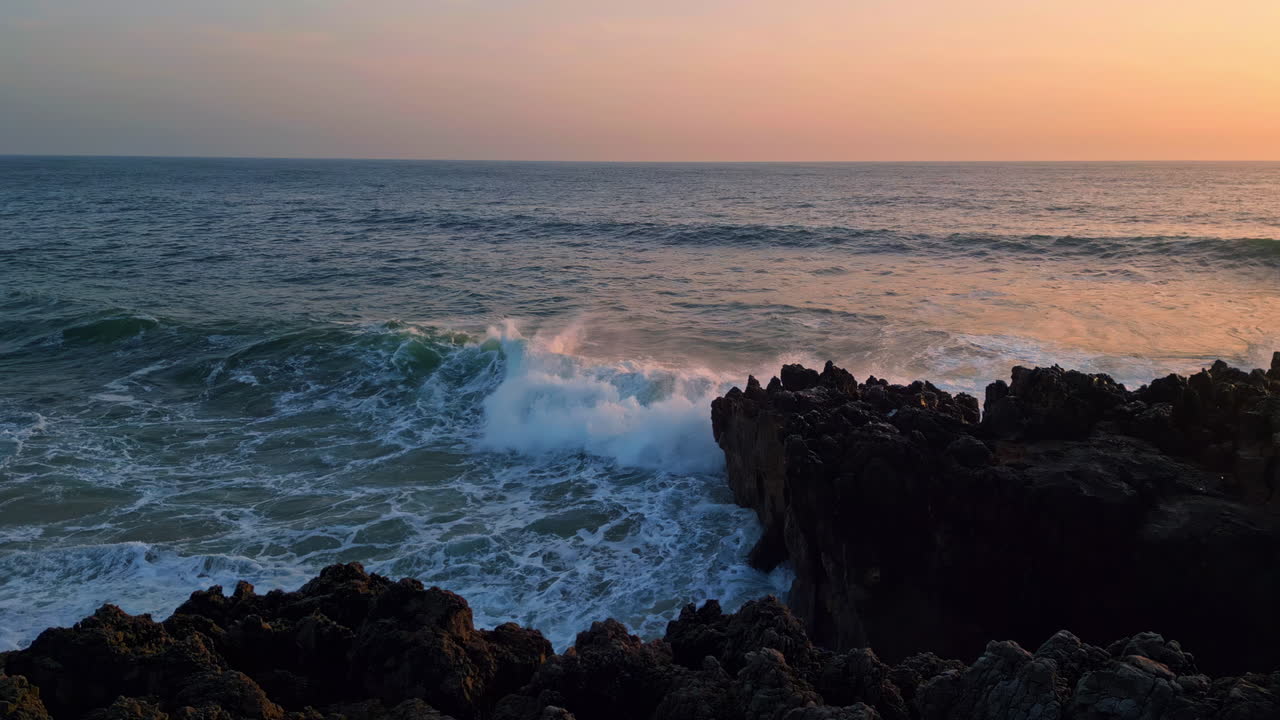 dramático océano rompiendo rocas colina de la mañana primer plano. olas del mar chocando contra las piedras