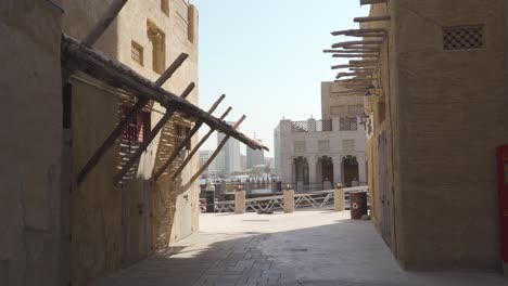 camine por la calle de dubai heritage village en el distrito histórico de al fahidi con paisaje urbano de fondo en los emiratos árabes unidos