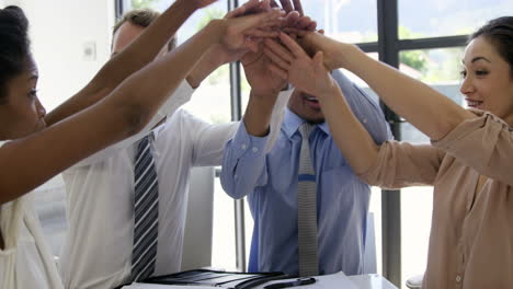 Smiling-business-people-putting-hands-together