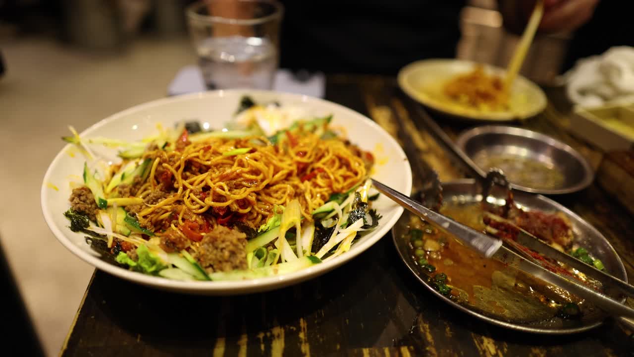 접시에서 가락으로 누들을 먹는 사람