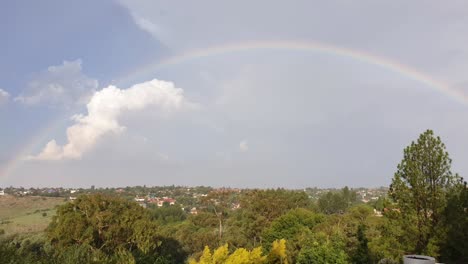 Lapso-De-Tiempo-Con-El-Arco-Iris-Después-De-Una-Tormenta-Mientras-Las-Nubes-Se-Alejan-Y-El-Sol-Brilla-Sobre-El-Barrio-Suburbano-De-Sudáfrica