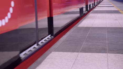 low angle: clean red subway train doors close and train leaves station