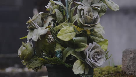 rising-up-shot-of-Beautiful-roses-in-a-flower-pot-on-top-of-a-grave-a-rainy-day-in-pere-lachaise-cemetary