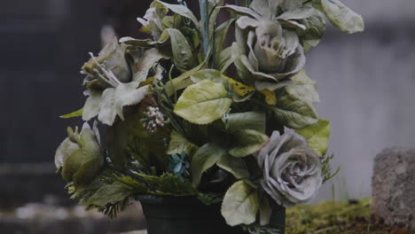 tiro ascendente de hermosas rosas en una maceta encima de una tumba un día lluvioso en el cementerio pere lachaise
