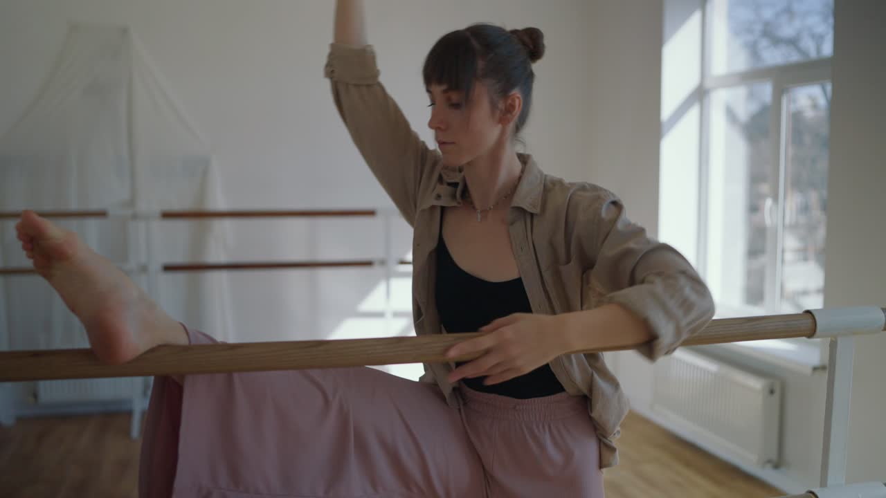 bailarín de ballet que se estira en la barra