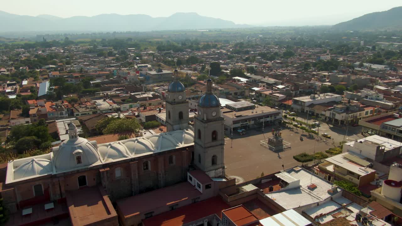 Aerial orbit around San Juan Bautista temple and Cruz Atrial in Tuxpan, Jalisco, Mexico