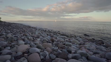 playa rocosa y barco marinero al atardecer