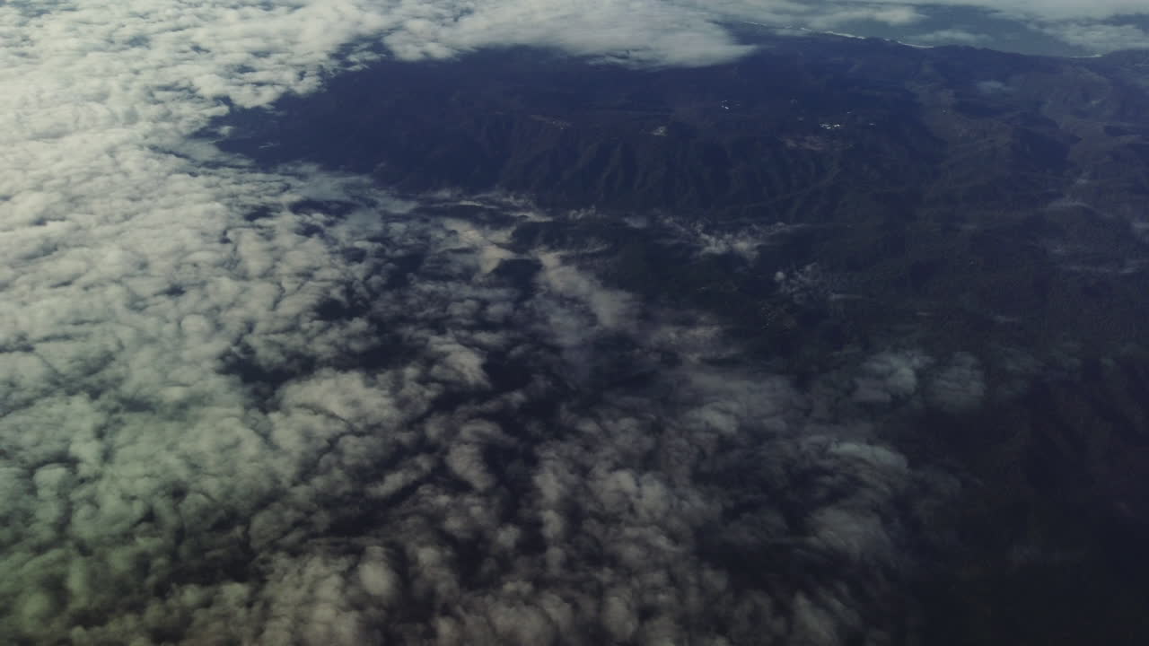 una vista aérea cinematográfica de montañas y nubes tomada desde un avión sobre las montañas de santa cruz de california
