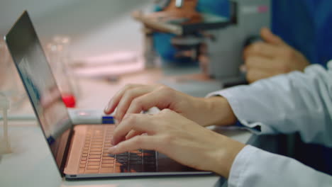 manos de científico escribiendo en el teclado de la computadora portátil. mano de médico mujer escribiendo computadora portátil
