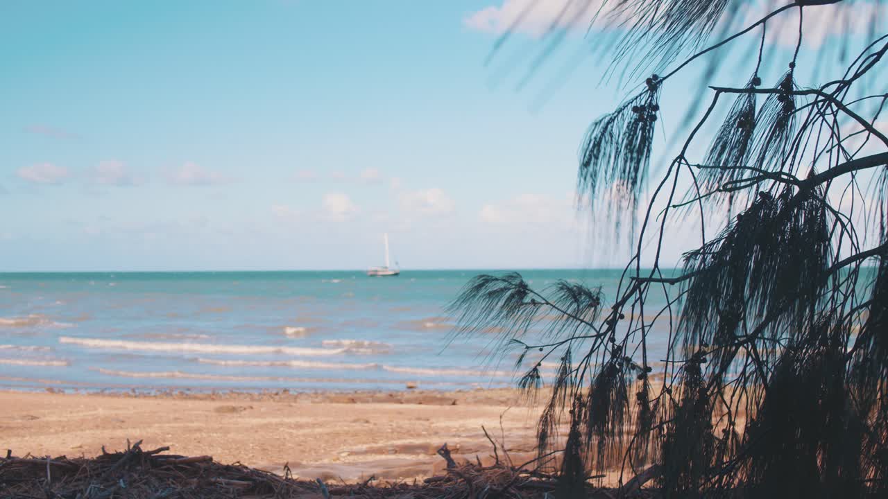 небольшая лодка плывет в красивых, голубых, тропических водах под теплым, солнечным небом недалеко от скалистого берега