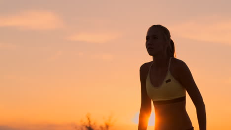 Middle-distance-volleyball-girl-in-bikini-waiting-for-the-ball-on-the-court-at-sunset-gives-forearm-pass-during-a-match-on-the-beach-in-slow-motion.