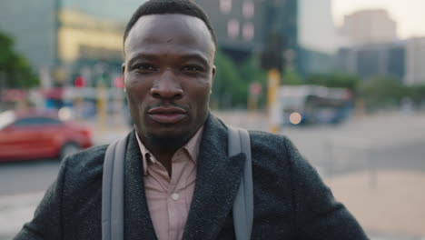 portrait of attractive young african american businessman looking serious intense at camera on busy urban city sidewalk