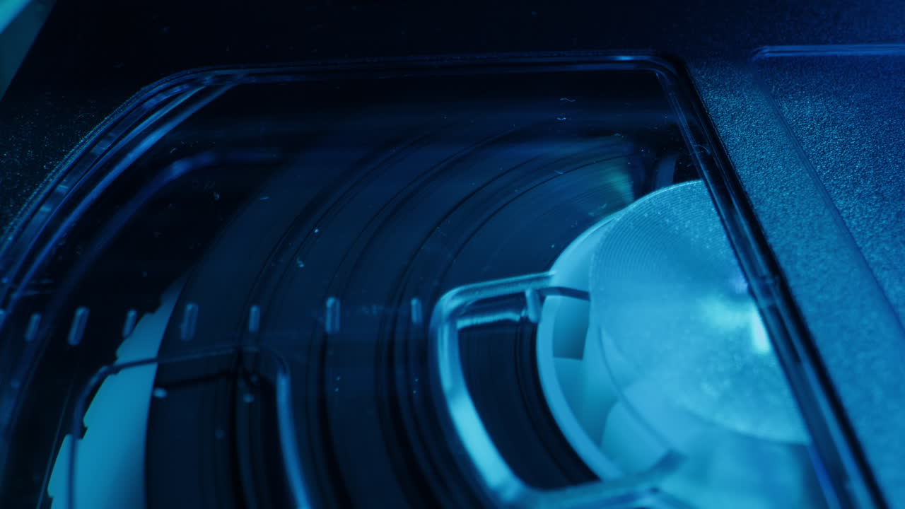 Old video recorder inside close-up, VHS. Retro player in neon blue light, vintage video cassette broadcasting, audio tape.