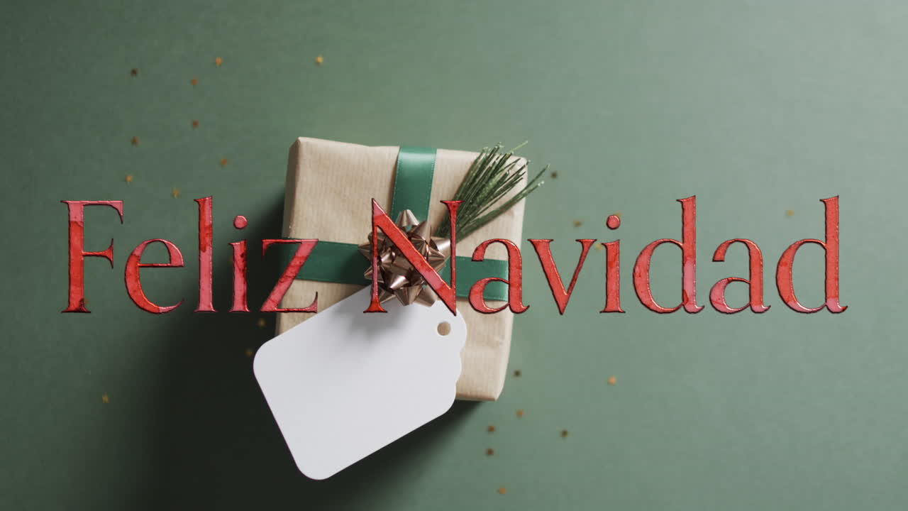 fekiz navidad texto en rojo sobre regalo de navidad con etiqueta en blanco en fondo verde