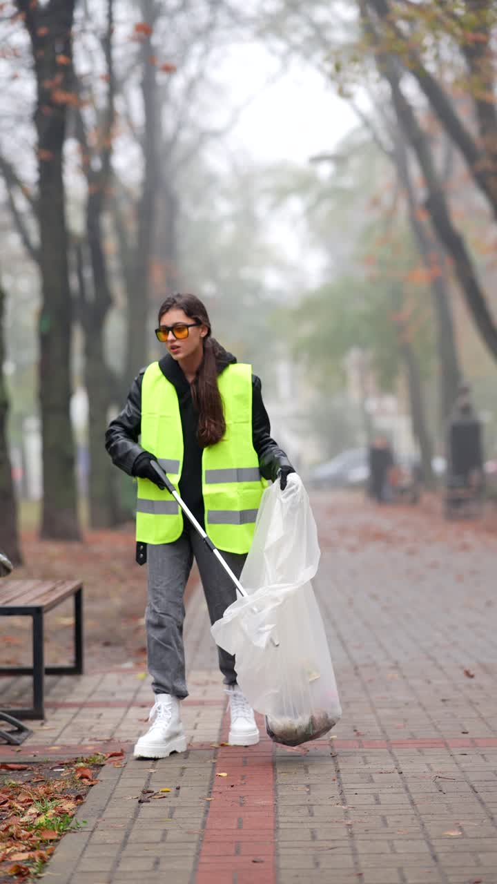 mujer limpiando la basura en un parque