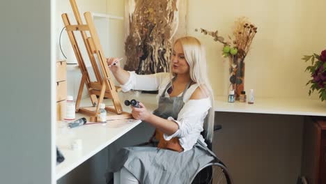 A-cute-fair-haired-girl-in-a-wheelchair-draws