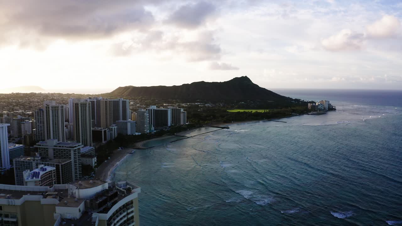 Drone shot of Diamond Head sitting tall over Oahu's condominium complexes