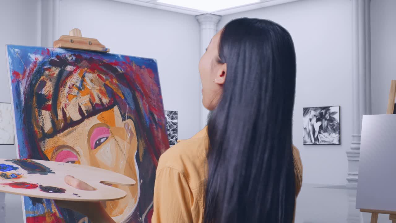 아시아 여성 예술가가 캔버스 위의 그림을 보고 갤러리에서 오일 페인트와 으로 그림을 그리는 동안 와우라고 말합니다.