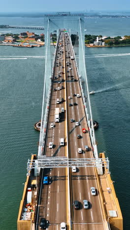 flying along the six lane road on the throgs neck bridge. multiple boats float over the east river.