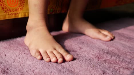 los pies del niño en una alfombra púrpura