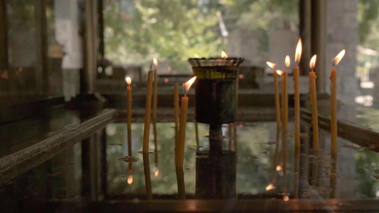 Ripresa al rallentatore di candele che bruciano in un tempio greco.