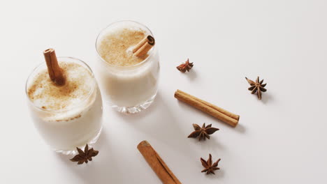 video of cups of hot chocolate with cinnamon over white background