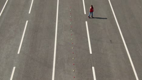 woman athlete rides on roller skates, makes a figure eight by kicking. slalom elements, criss cross. aerial view, professional roller skating training. 4k, 10bit, prores