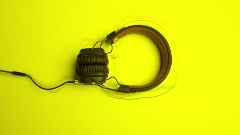 black headphones on a bright yellow background