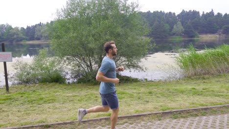 athletic man jogging by the lake.