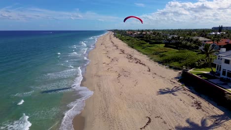 Ein-Erstaunliches-Drohnenvideo,-Das-Einem-Gleitschirm-Am-Strand-Folgt