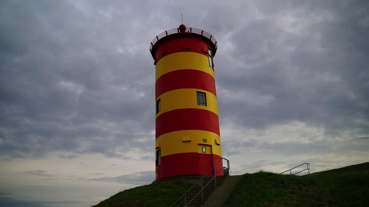 faro amarillo rojo en el norte de alemania en la duna junto al mar por la noche