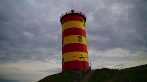 Red-yellow-lighthouse-in-the-north-of-Germany-on-the-dune-by-the-sea-in-the-evening