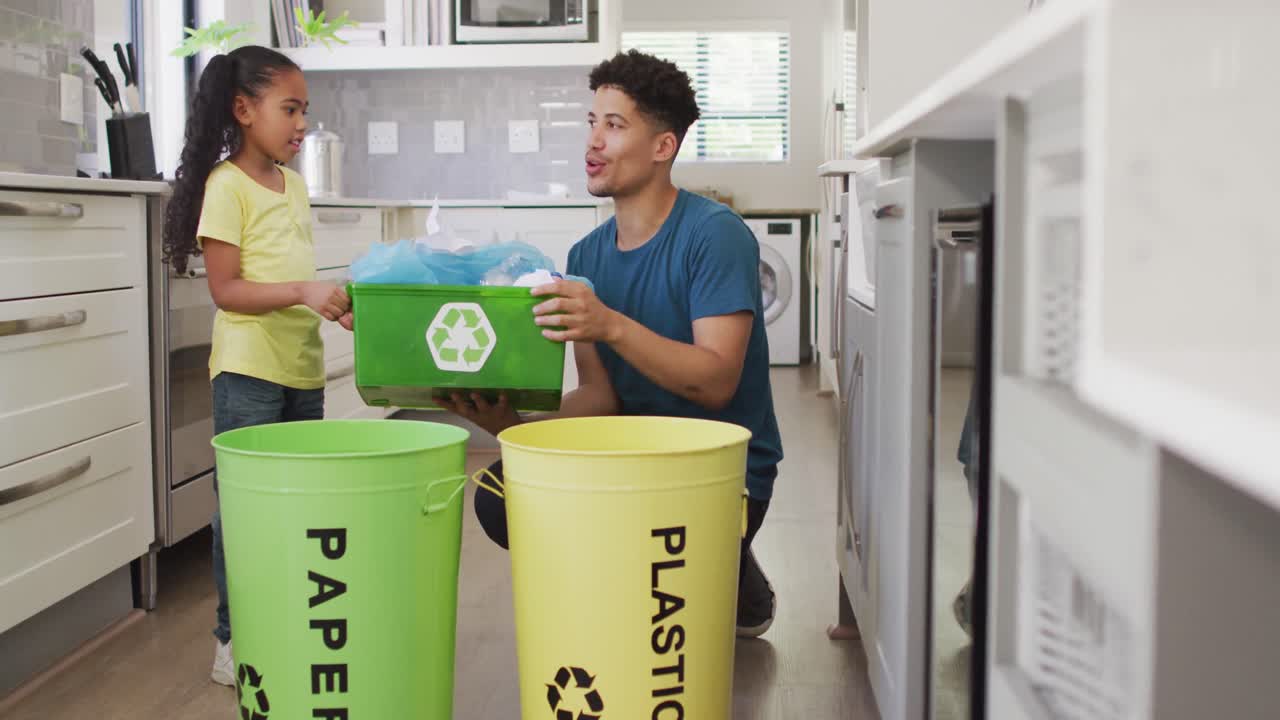 행복한 이종족 아버지와 딸이 함께 쓰레기를 분류하고 있습니다.