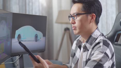 man working on car design using computer and smartphone