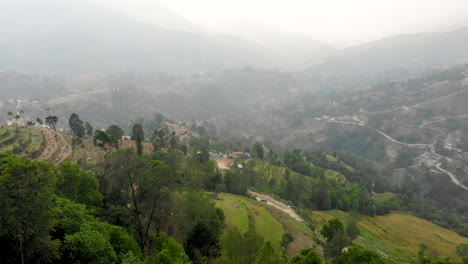 aerial following a car driving on dirt road in the mountains
