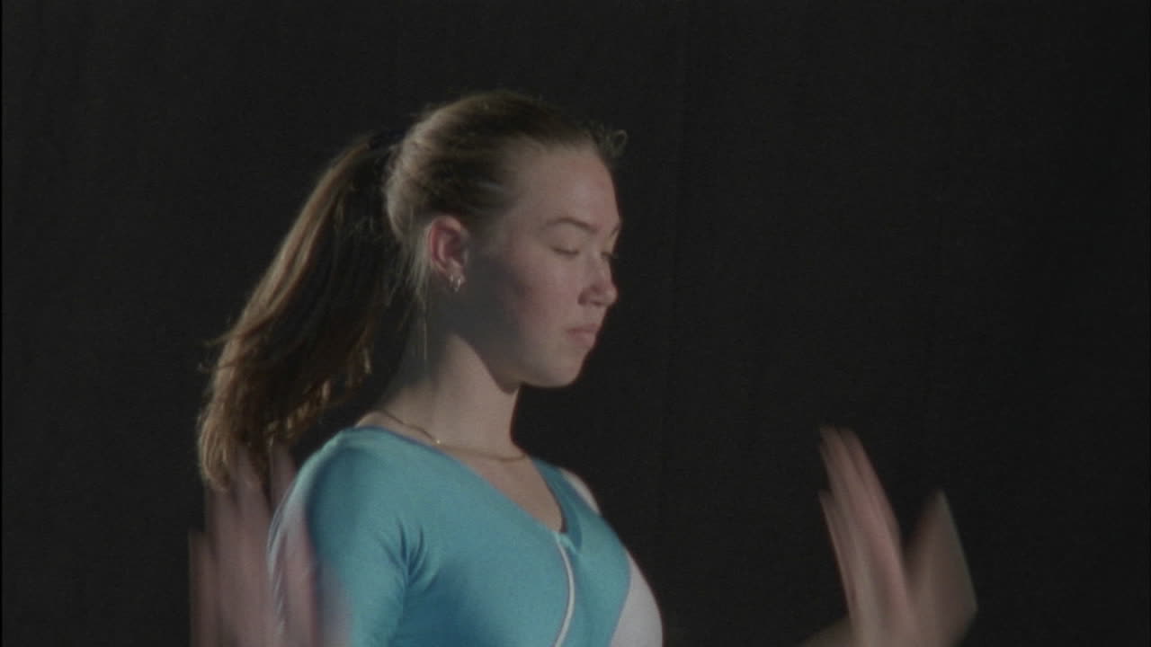 joven gimnasta actuando en una barra de equilibrio