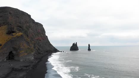 Reynisdrangar-basalt-sea-stack-columns-and-volcanic-black-sand-beach