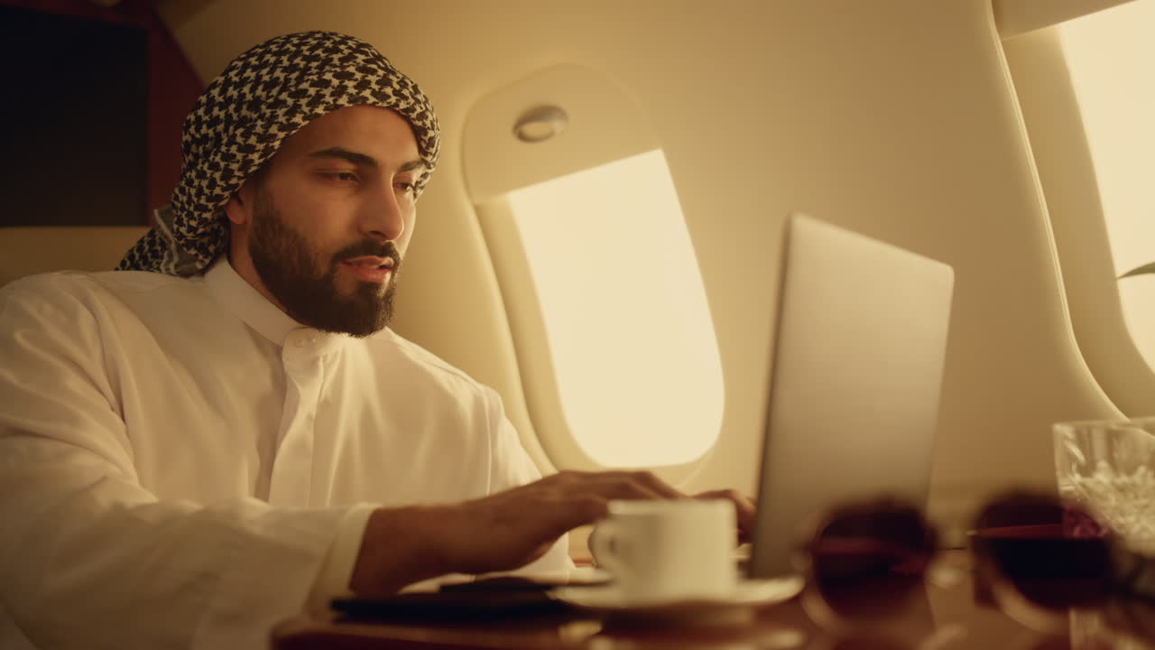Positive ceo typing laptop on business trip closeup. Smiling arabian enjoying