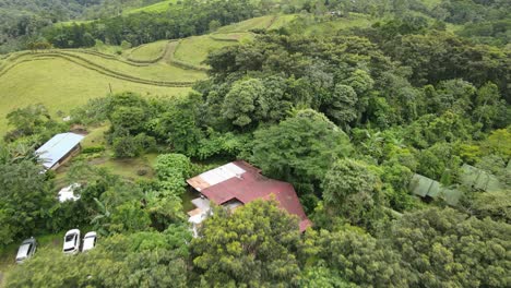 aerial view moving forward shot, scenic view landscape of la tigra rain forest in costa rica, houses in the background