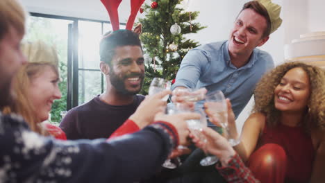 group of friends celebrating with champagne after enjoying christmas dinner at home