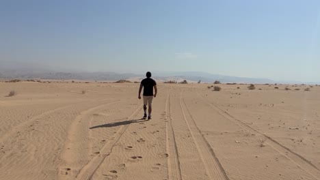 man walking through the desert