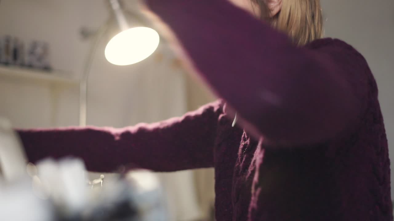 창의적 인 여성 은 작업실 에서 천 을 짜는 기계 에  ⁇  을 조절 하고 있다