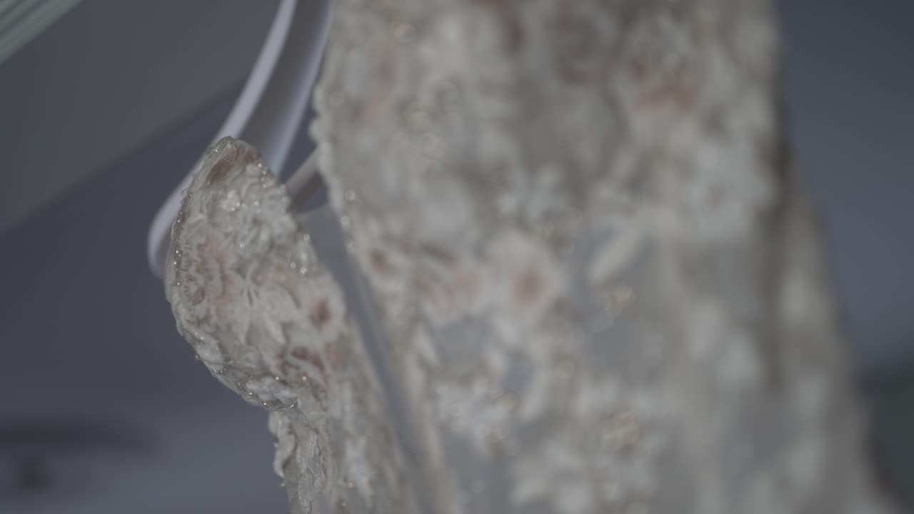 Close up of floral lace wedding gown, highlighting its intricate embroidery and delicate design