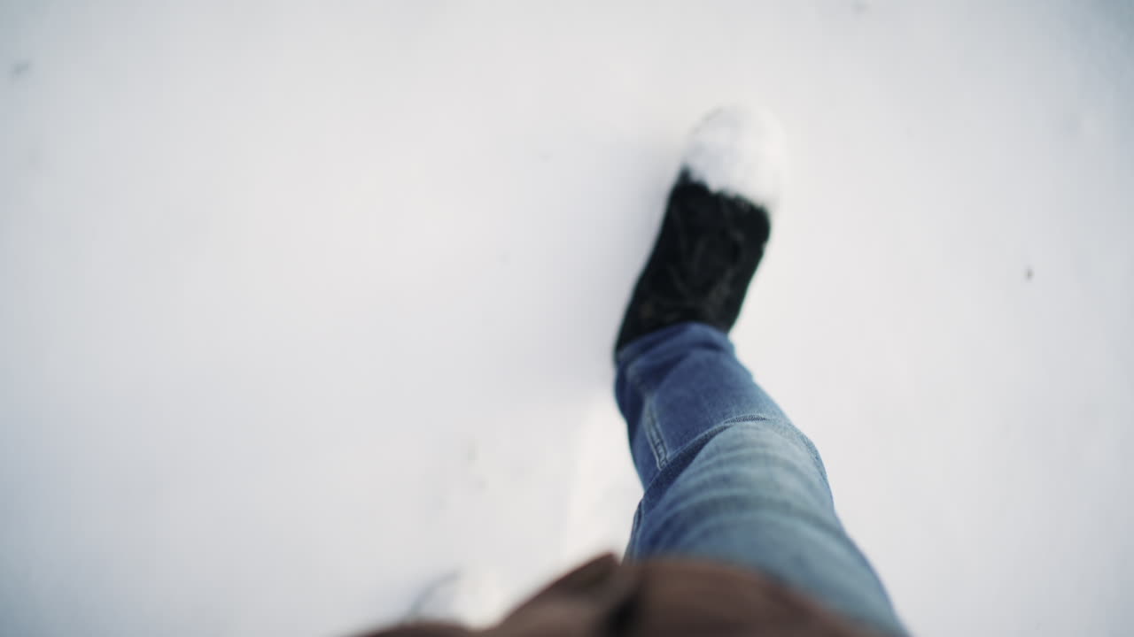 Point of view shot of person walking through fresh snow wearing winter boots