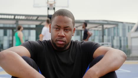 Basketball-player-sitting-in-basketball-court-4k